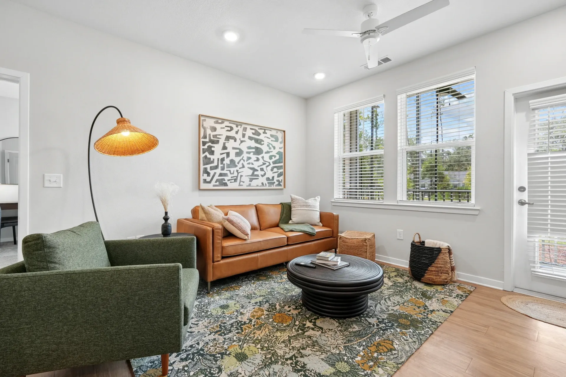 Modern living room with a brown leather sofa, green armchair, and coffee table.