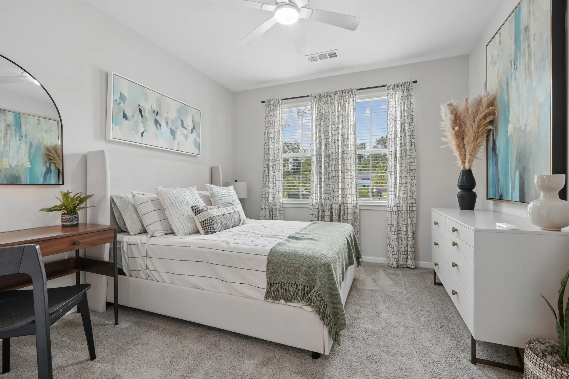 Bedroom with a queen-size bed, desk, and dresser.