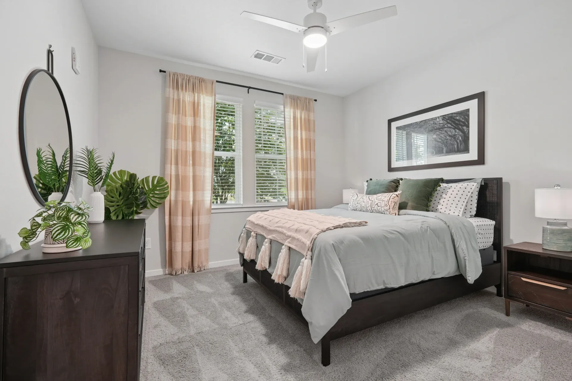 Bedroom with a queen-size bed, dresser, and mirror.