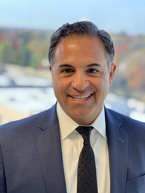 A man in a suit and tie is smiling for the camera.