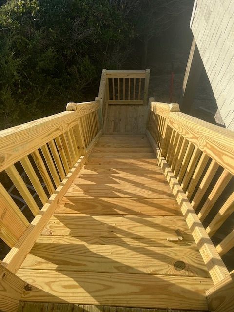 Wooden outdoor staircase leading up, with railings on both sides.