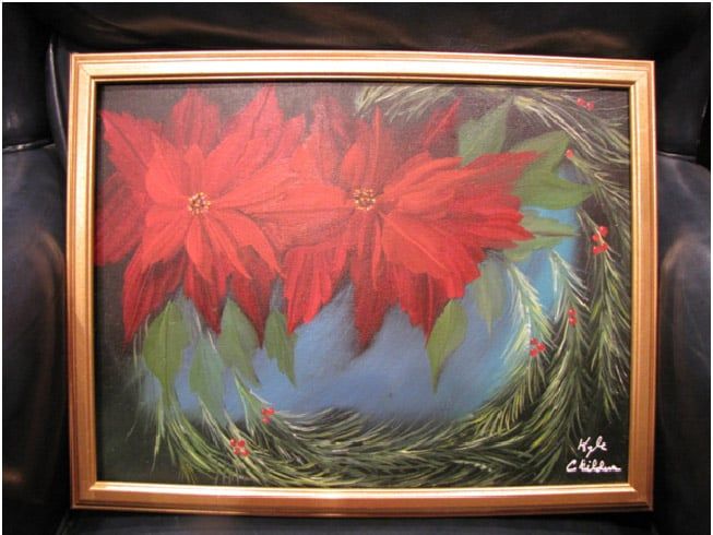 A painting of poinsettia flowers in a gold frame