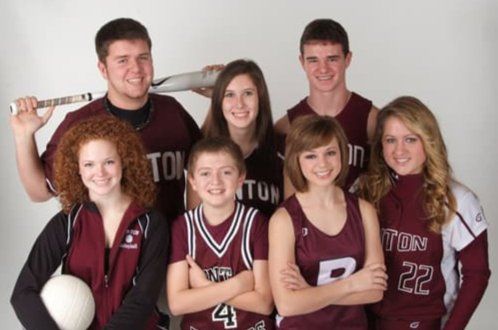 A group of young people are posing for a picture and one of them has the number 4 on his jersey