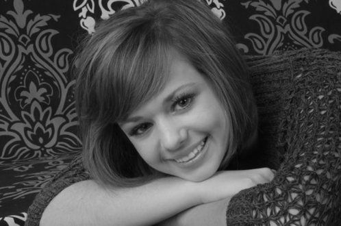 A woman is smiling in a black and white photo