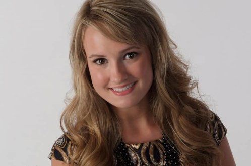 A woman with long blonde hair is smiling for the camera.