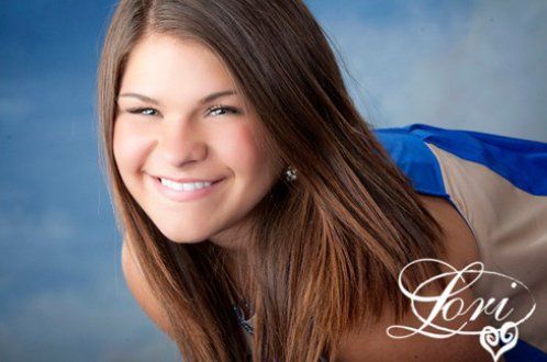 A girl with long hair is smiling with the name lori on the bottom