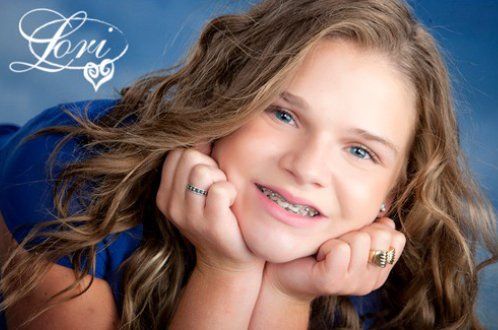 a blonde girl with braces is smiling