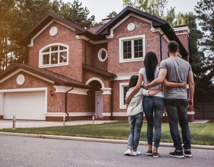 Family standing in front of a new home in Boulder, CO