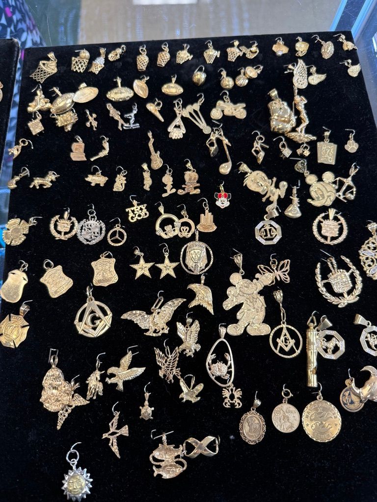 Assorted gold-tone earrings and pendants neatly arranged on black velvet display