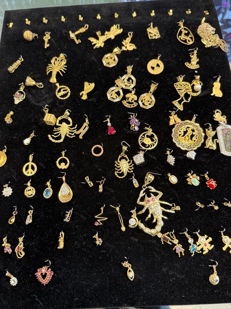 Assorted gold and colorful jewelry pieces arranged on black velvet display.