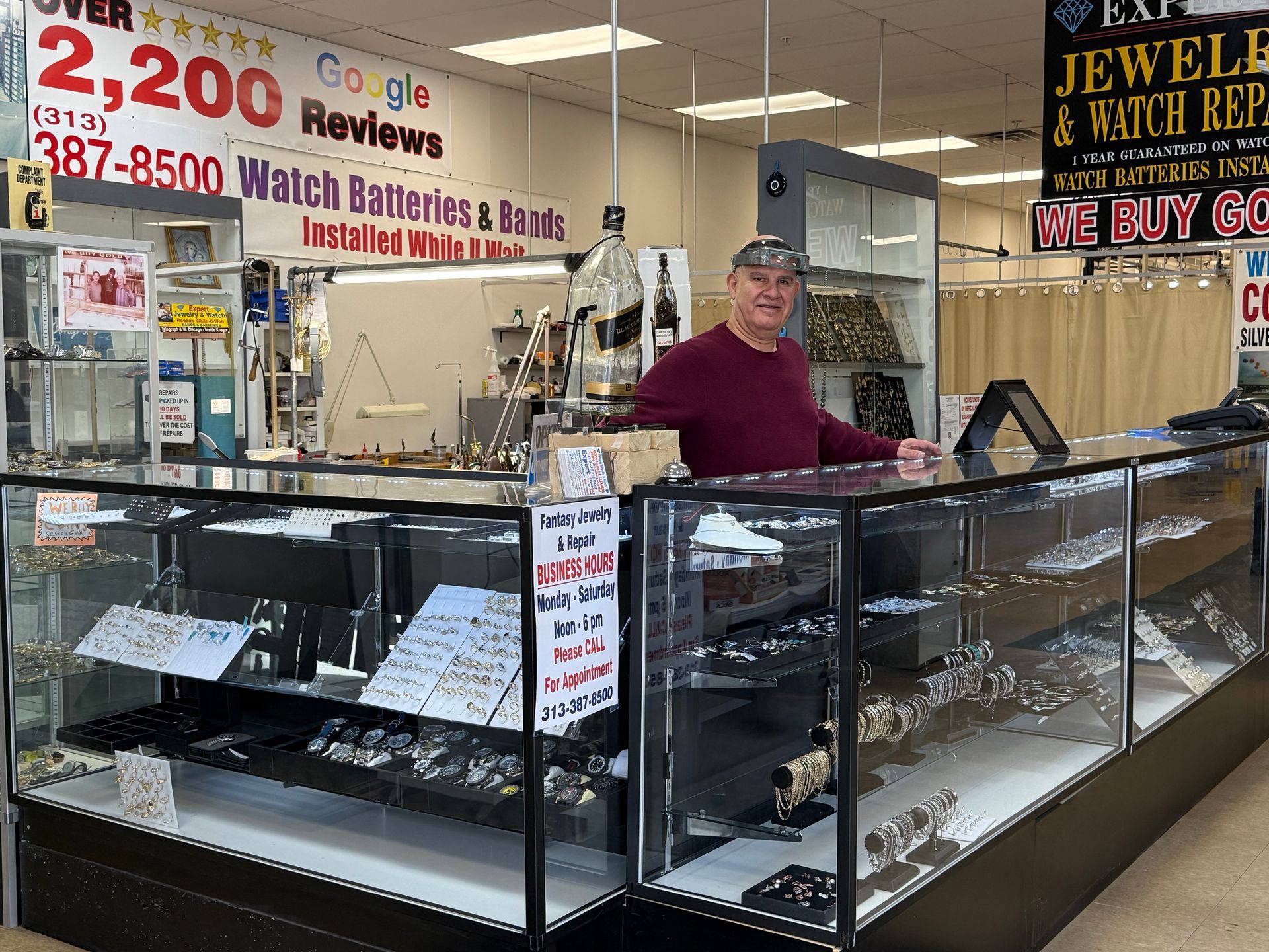 Jewelry store kiosk with glass display cases and a man standing behind the counter