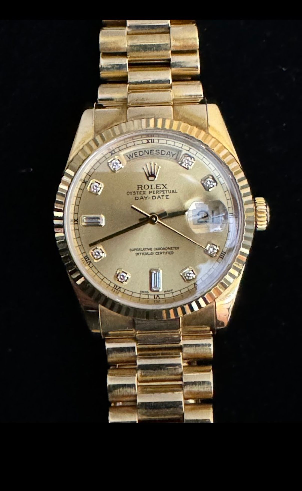 Gold Rolex watch with diamond markers and date magnifier on a matching gold bracelet