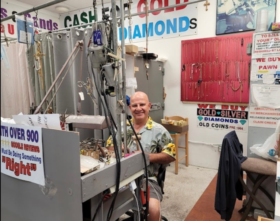 Jewelry booth with a smiling vendor amid display cases and signs for diamonds and cash loans
