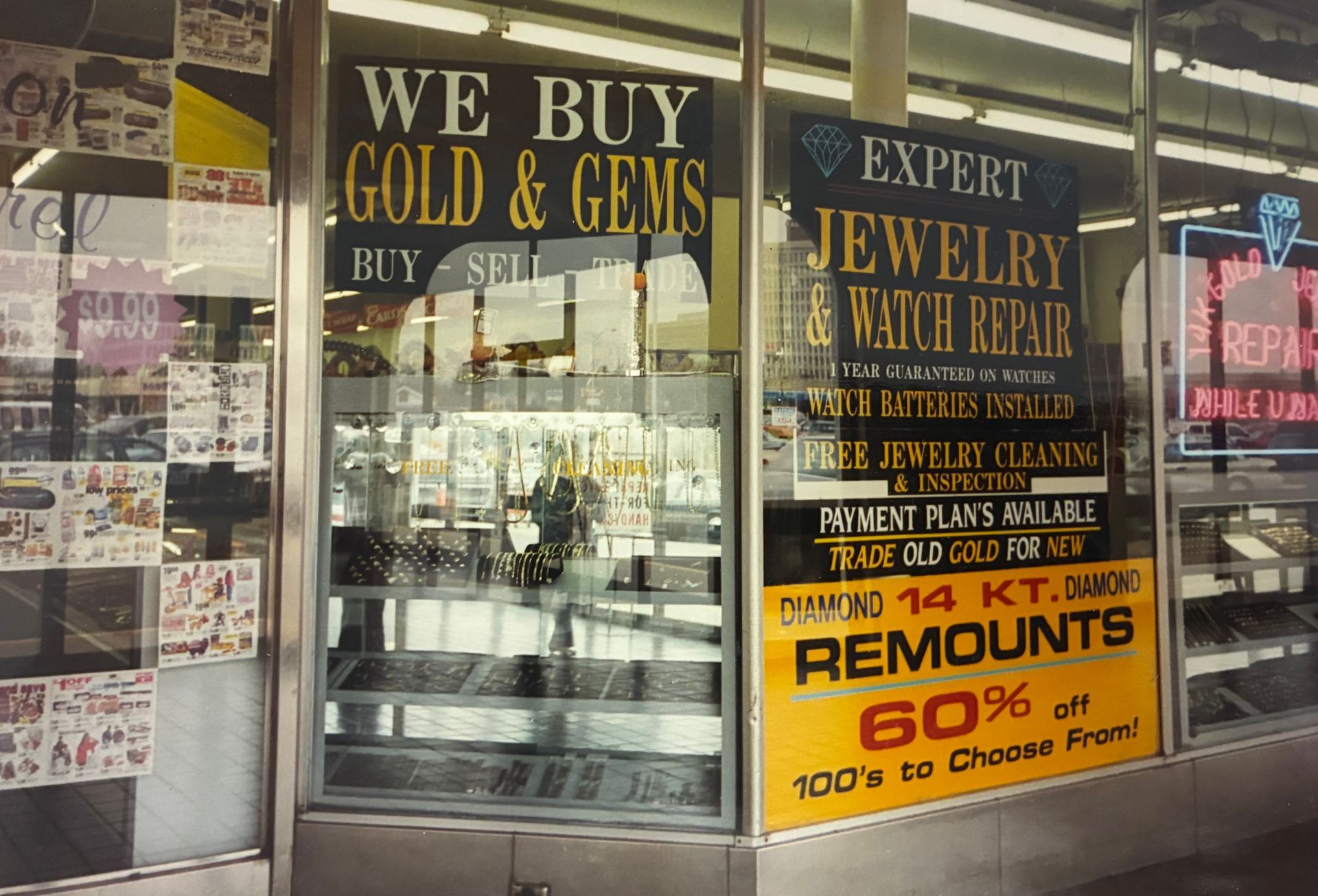 Jewelry and gold exchange storefront with signs reading “We Buy Gold & Gems” and “60% off.”
