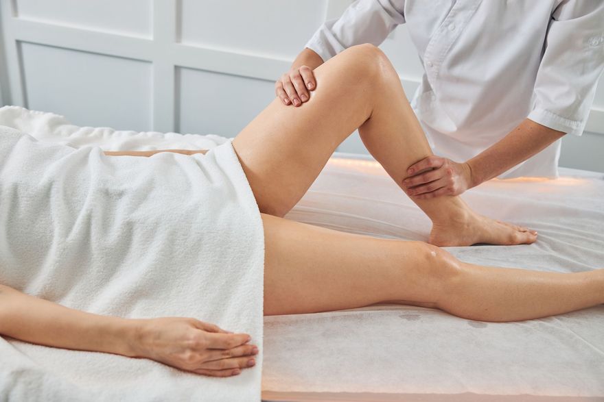 Una donna si sta facendo fare un massaggio alle gambe in una spa.