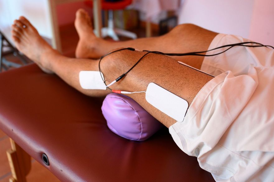 Una persona è sdraiata su un tavolo con gli elettrodi sulle gambe