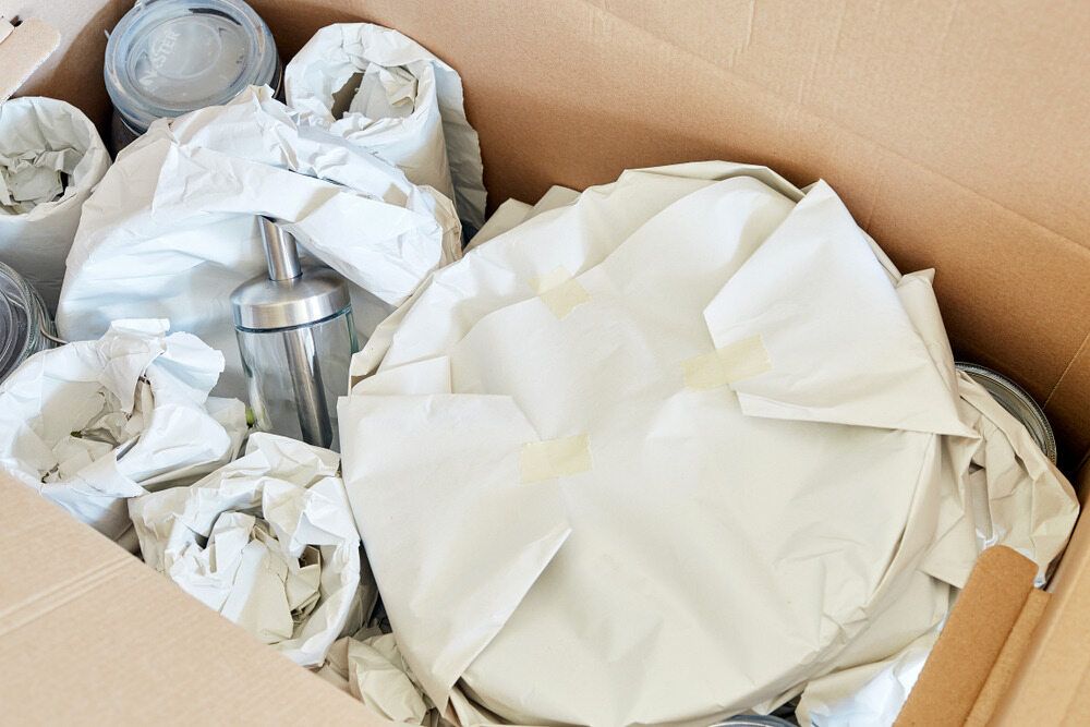 A Cardboard Box Filled With Items Wrapped in White Paper — A-Team Delivery Services Pty Ltd in Cessnock, NSW