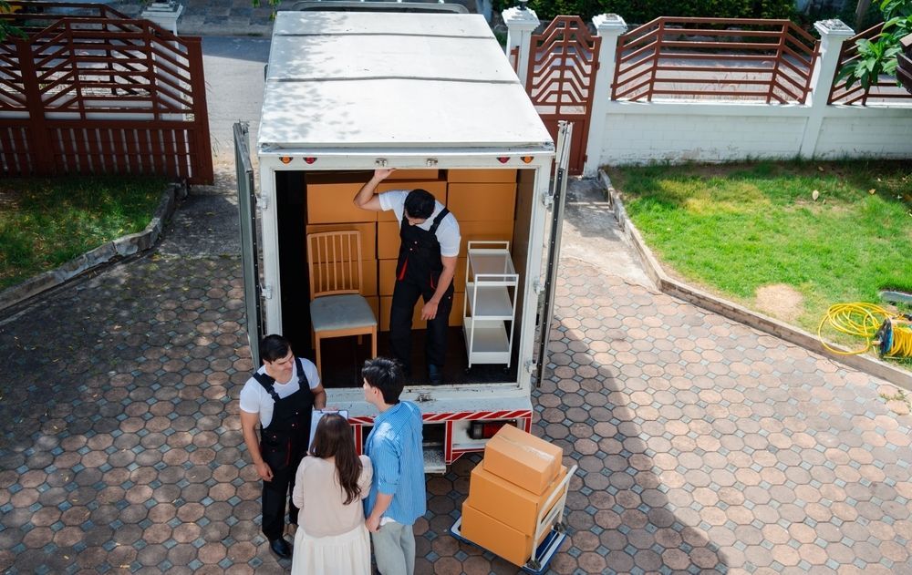 A Group of People Are Standing in Front of a Moving Truck — A-Team Delivery Services Pty Ltd in Newcastle, NSW
