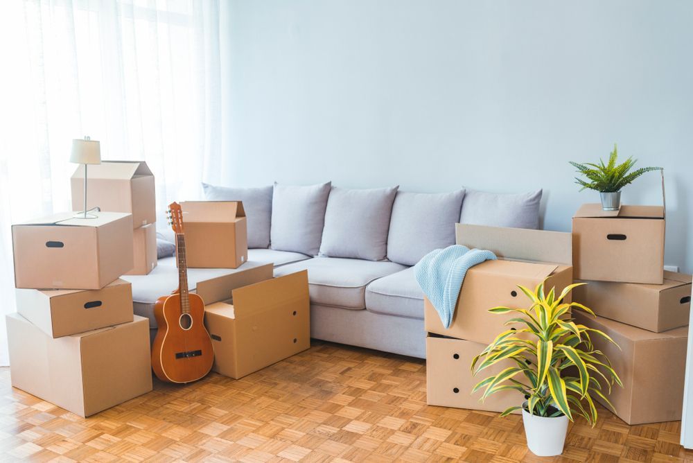 A Living Room Filled With Cardboard Boxes and a Guitar — A-Team Delivery Services Pty Ltd in Maitland, NSW