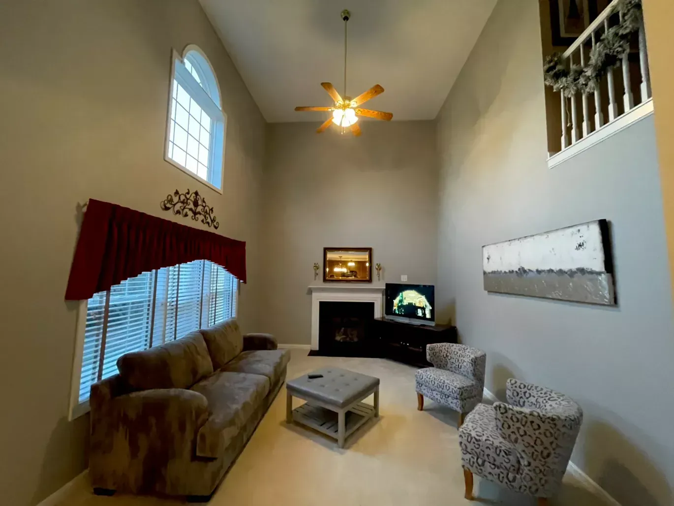 A living room with a fireplace and a ceiling fan