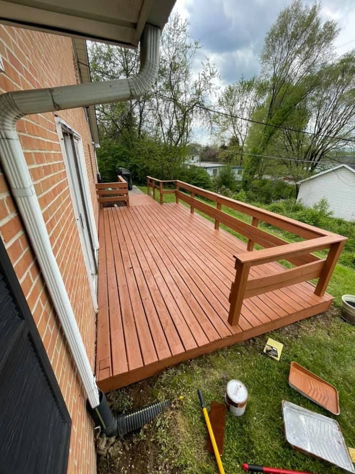 A wooden deck is being built on the side of a brick house.