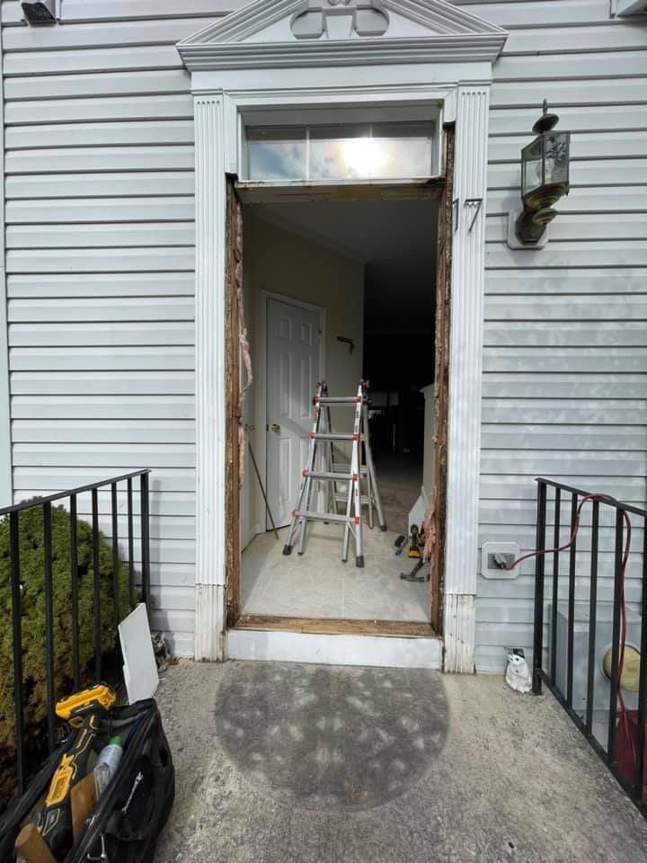 A ladder is sitting in front of a door that is being remodeled.