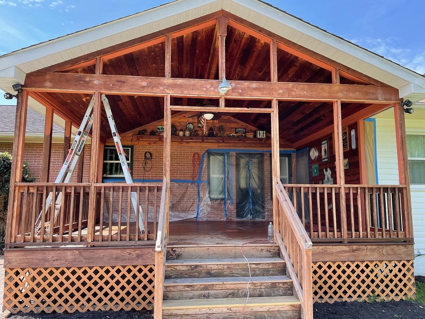 A house with a porch and stairs is being painted.
