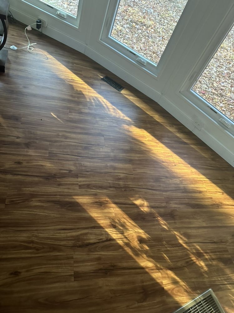 The sun is shining through the windows on the wooden floor.
