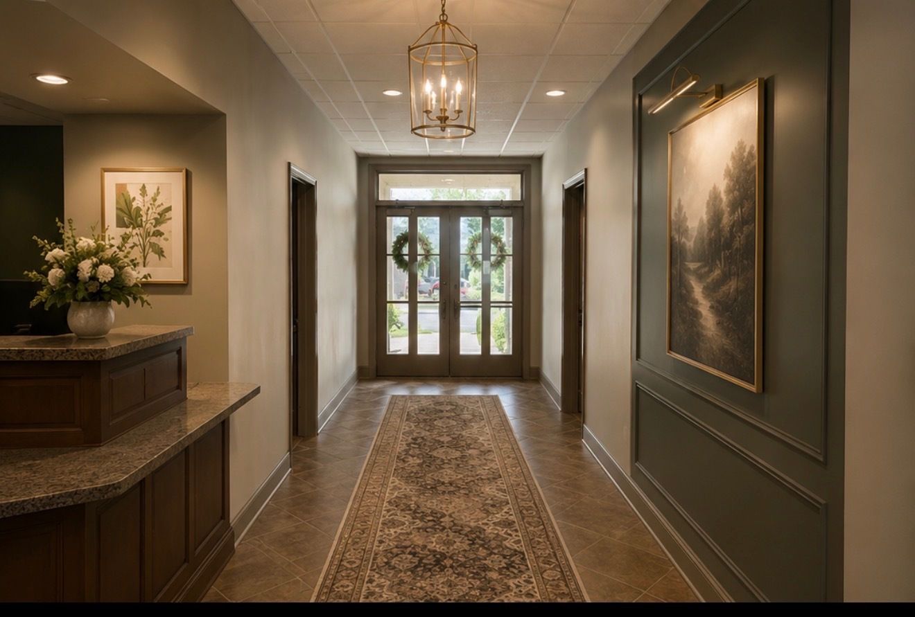 Elegant hallway with patterned runner, framed art, pendant light, and glass double doors at the end.
