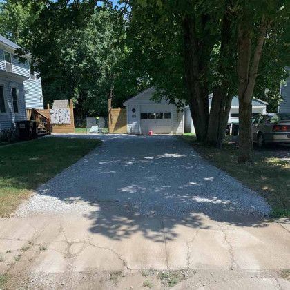 A car is parked in the driveway of a house.