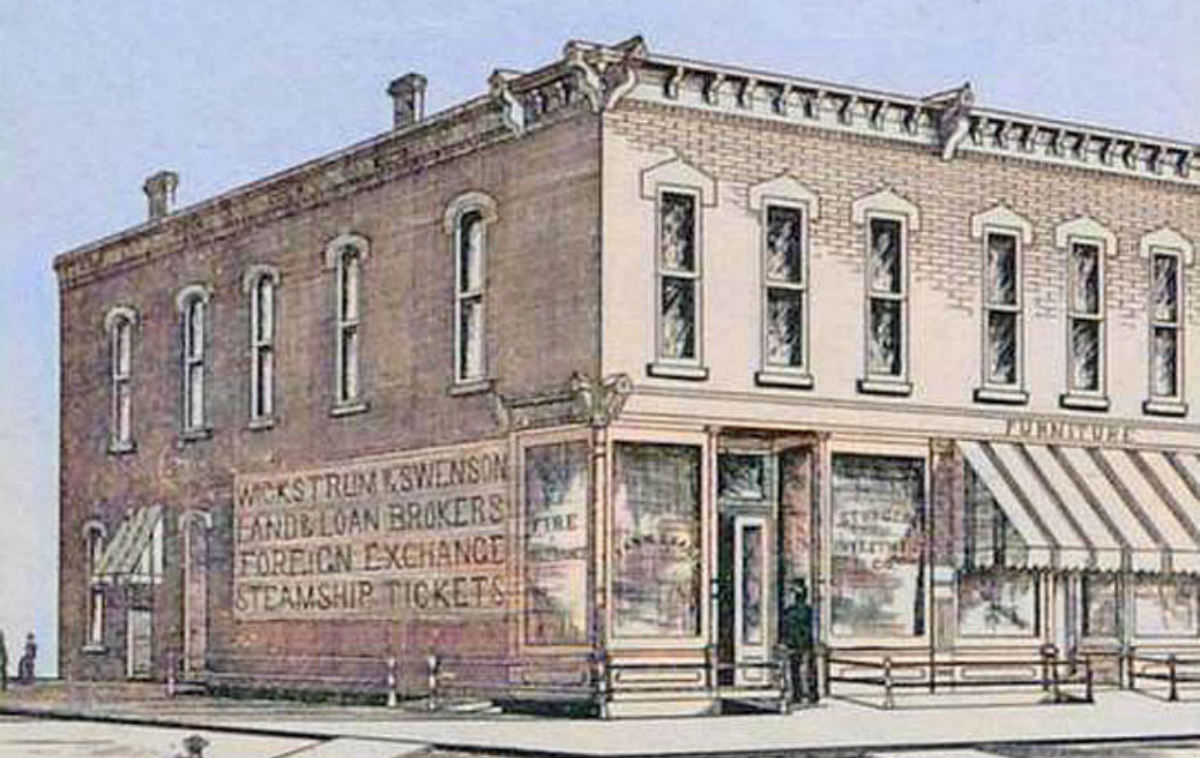 Historic brick corner store with faded painted sign and a person standing by the entrance