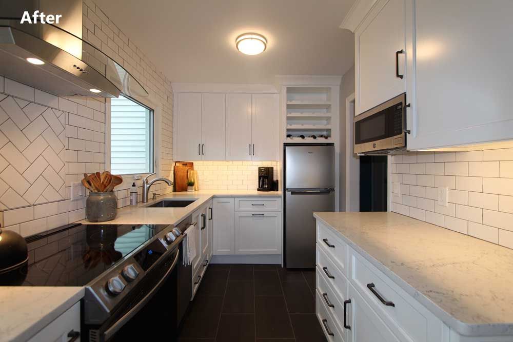 Bright modern kitchen with white cabinets, subway tile, dark floor, and stainless steel appliances