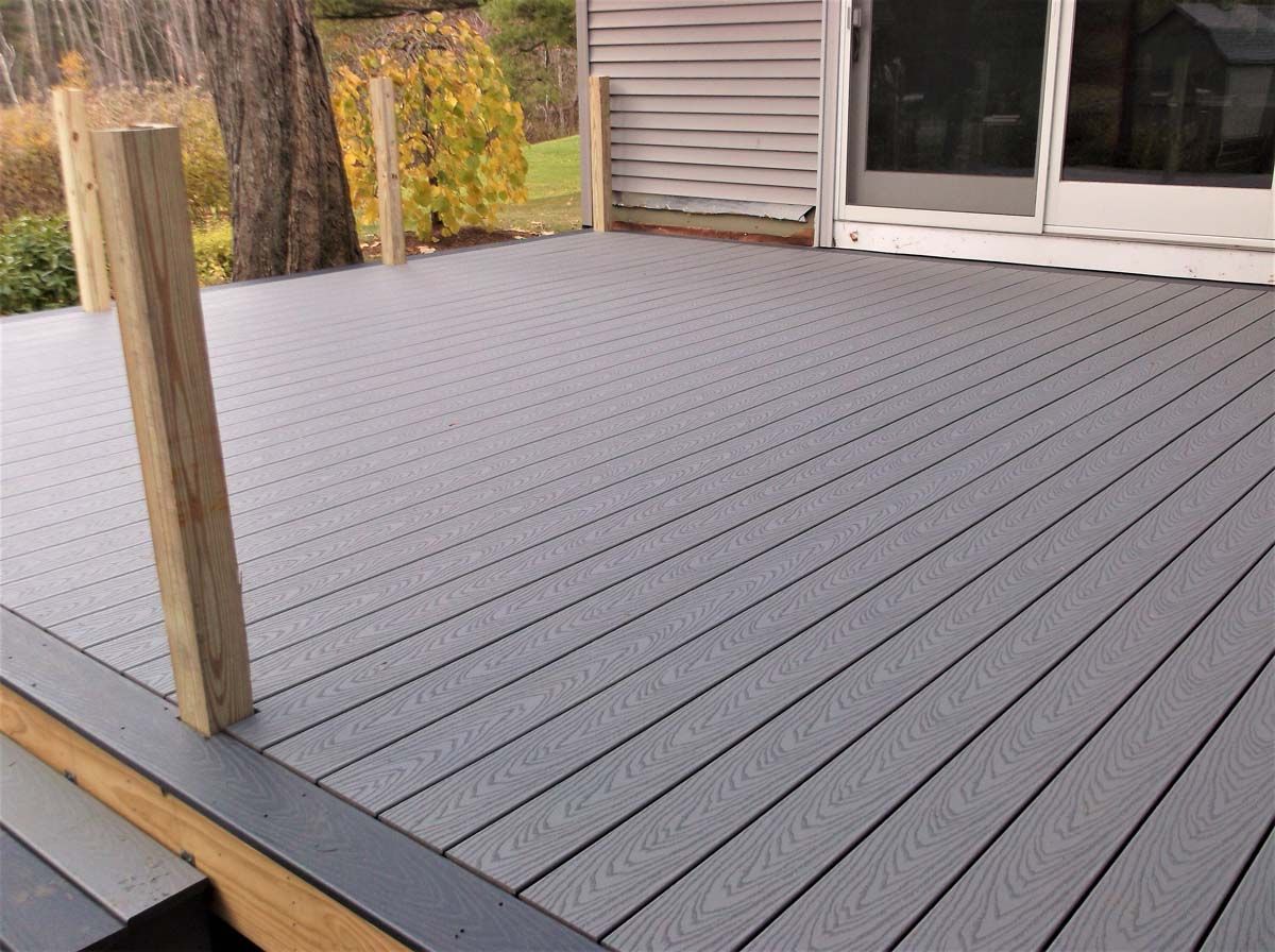 Gray composite deck with a wooden post beside a sliding glass door