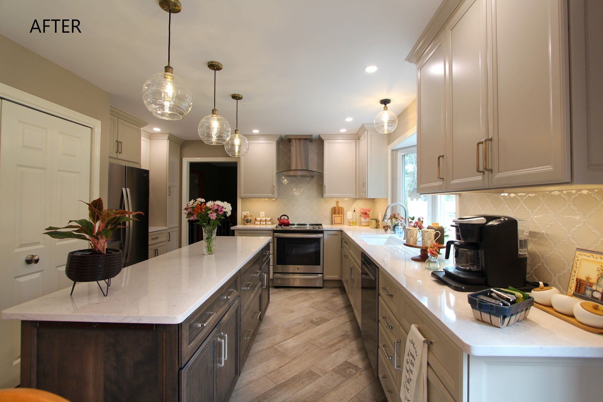 Bright modern kitchen with white island, gray cabinets, pendant lights, and coffee maker on the counter