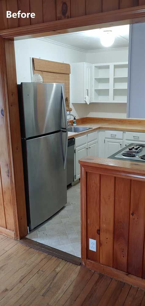 Small kitchen with stainless steel refrigerator, white cabinets, and wood-paneled counter in a “Before” view