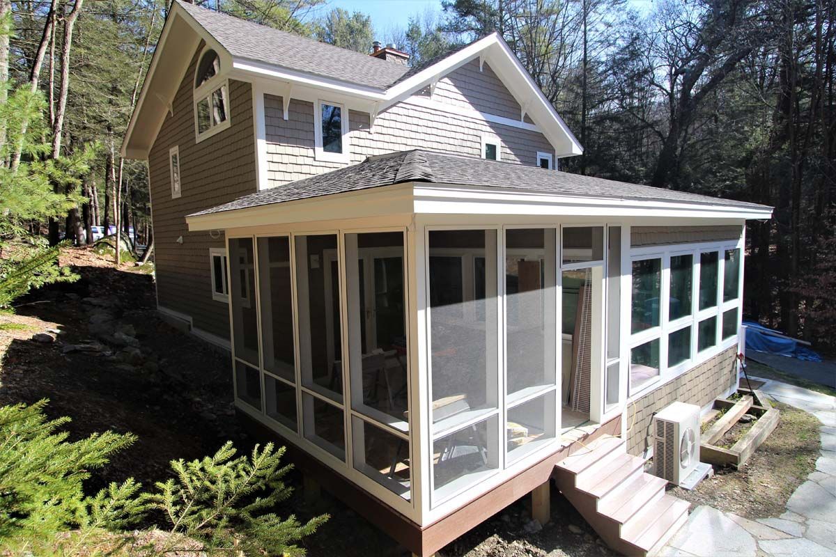 House with a screened-in porch on a wooded hillside