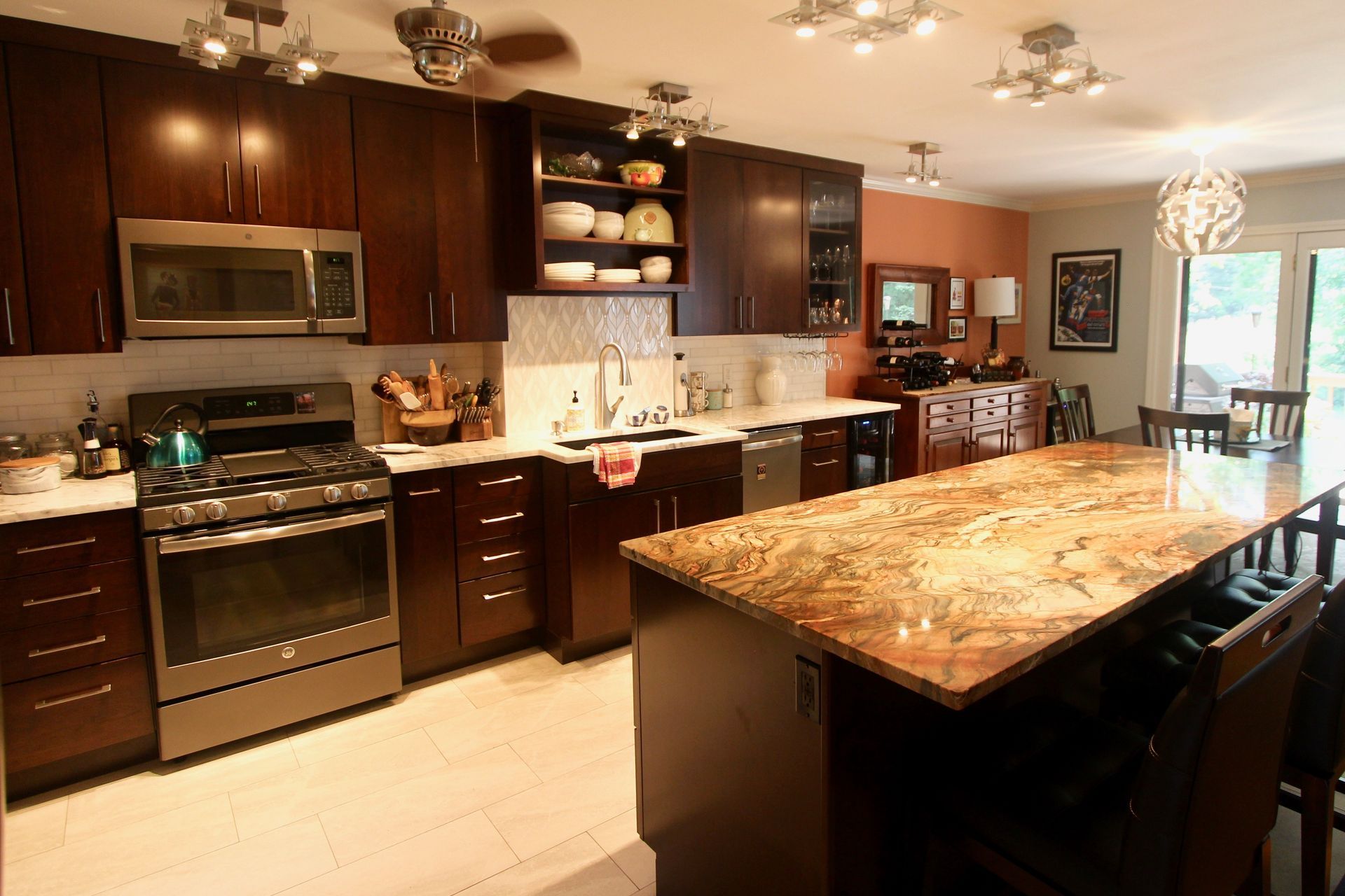Modern kitchen with dark cabinets, granite island, stainless appliances, and pendant lighting
