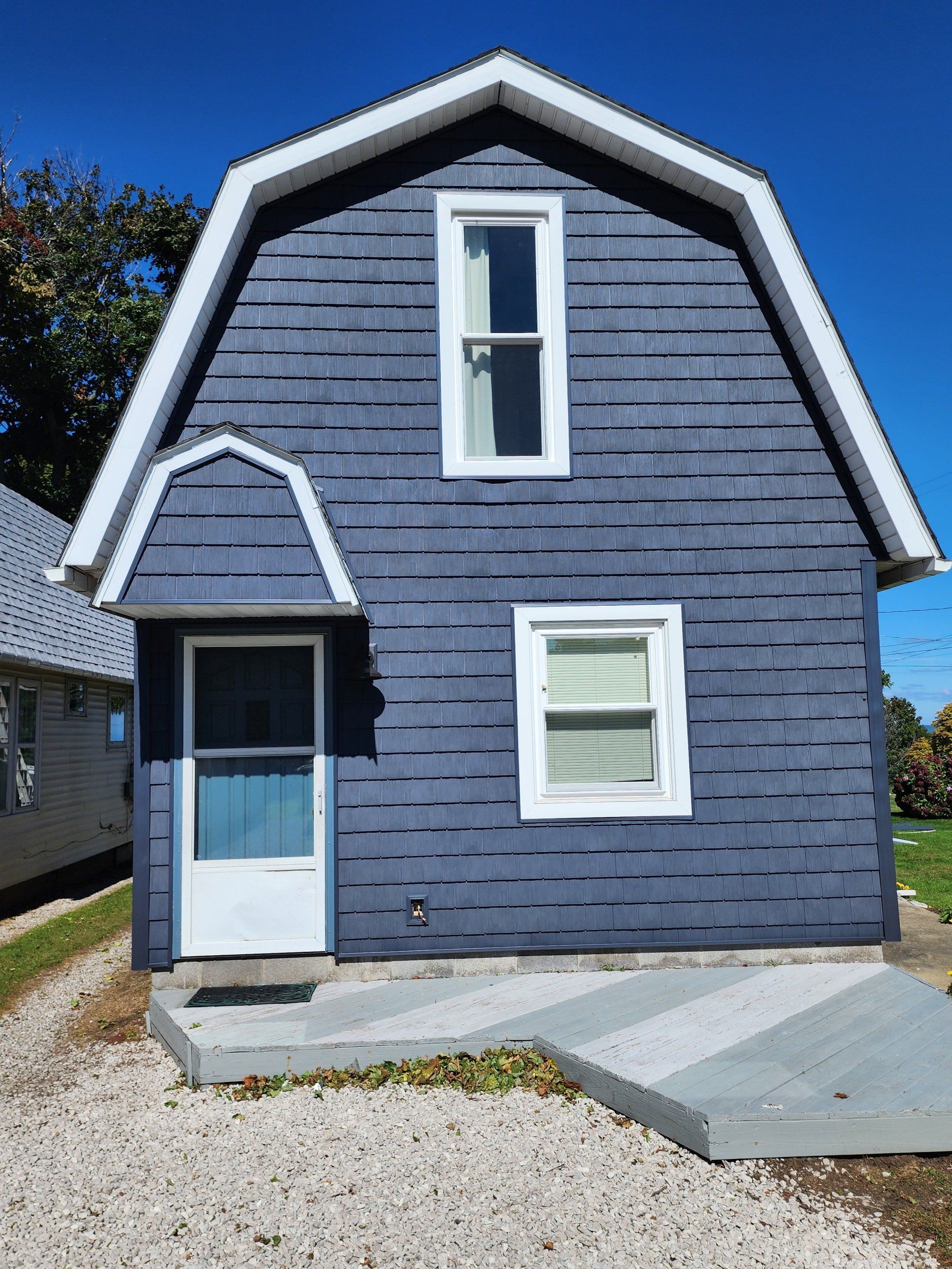 A blue house with a white door and windows