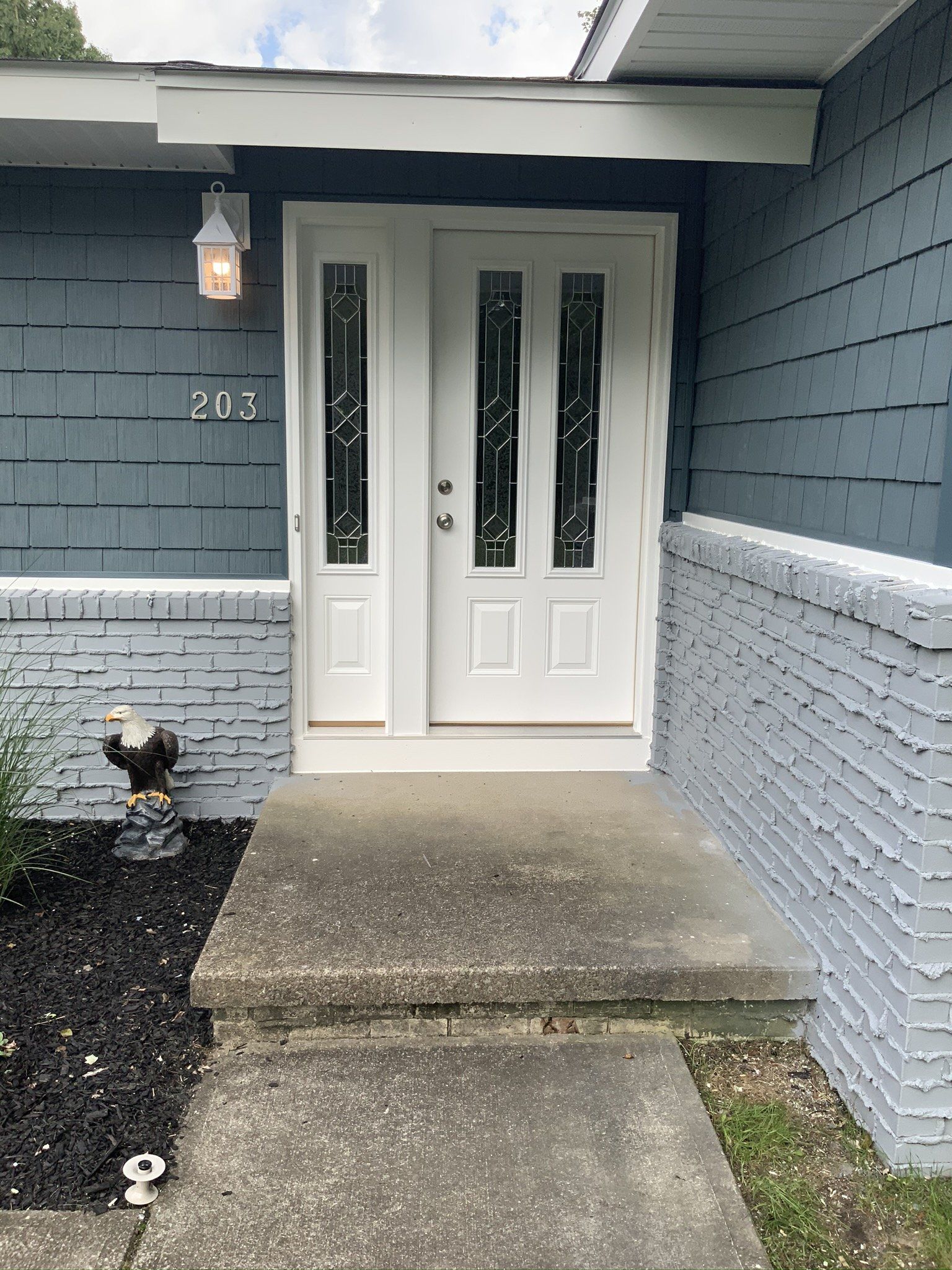 The front door of a house with a fire hydrant in front of it.