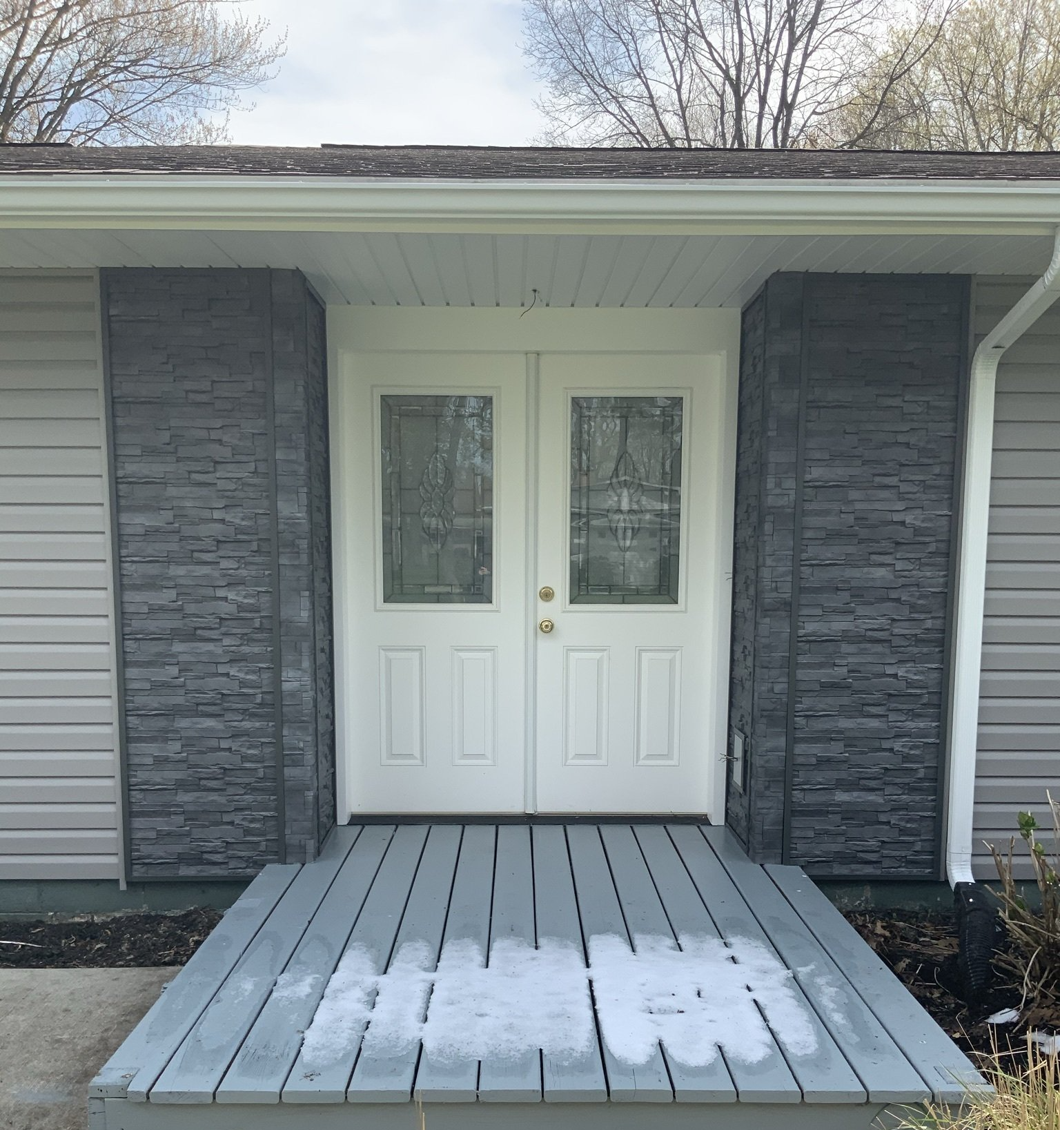 The front door of a house with snow on the porch