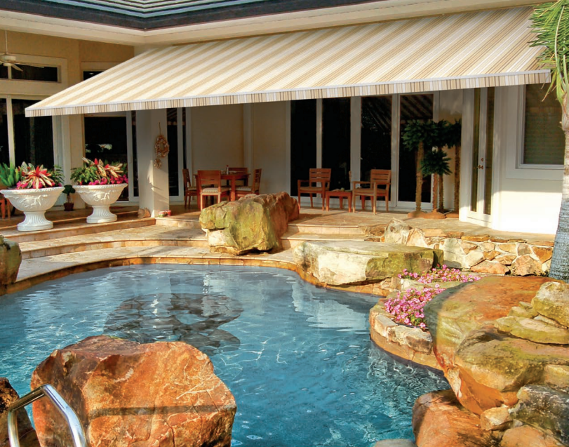 A swimming pool with a striped awning over it