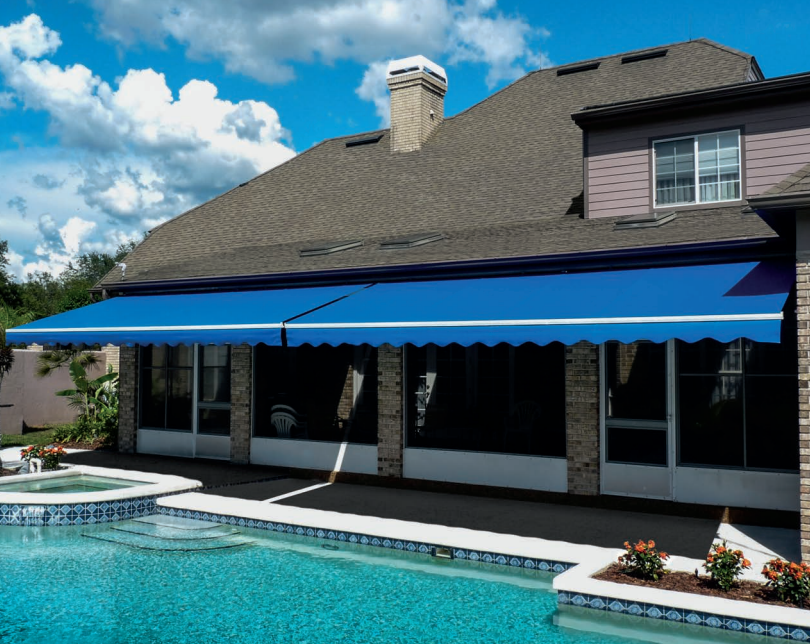 A house with a blue awning over a swimming pool