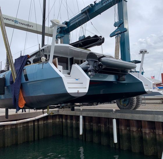 A boat is being lifted into the water by a crane