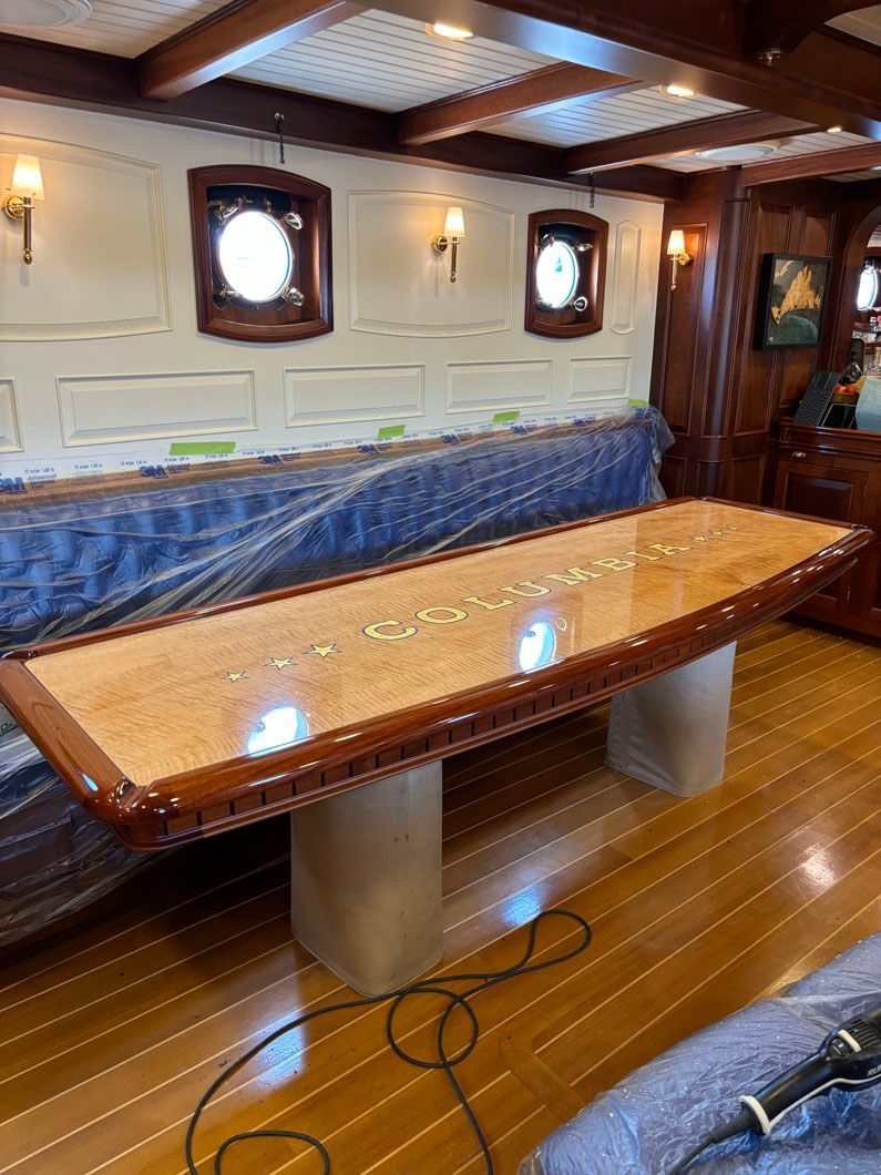A long wooden table is sitting on a wooden floor in a room.