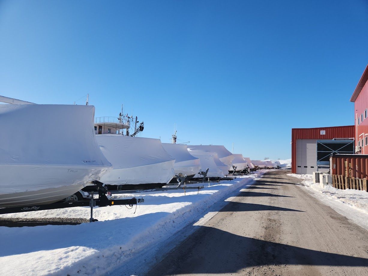 A snowy road with a red building in the background