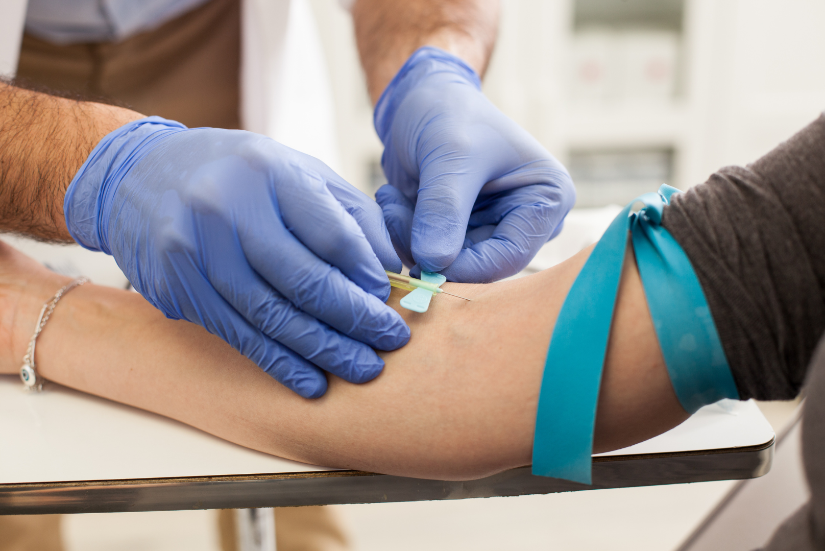 AllMed physician drawing blood from a community clinic patient for a lab test
