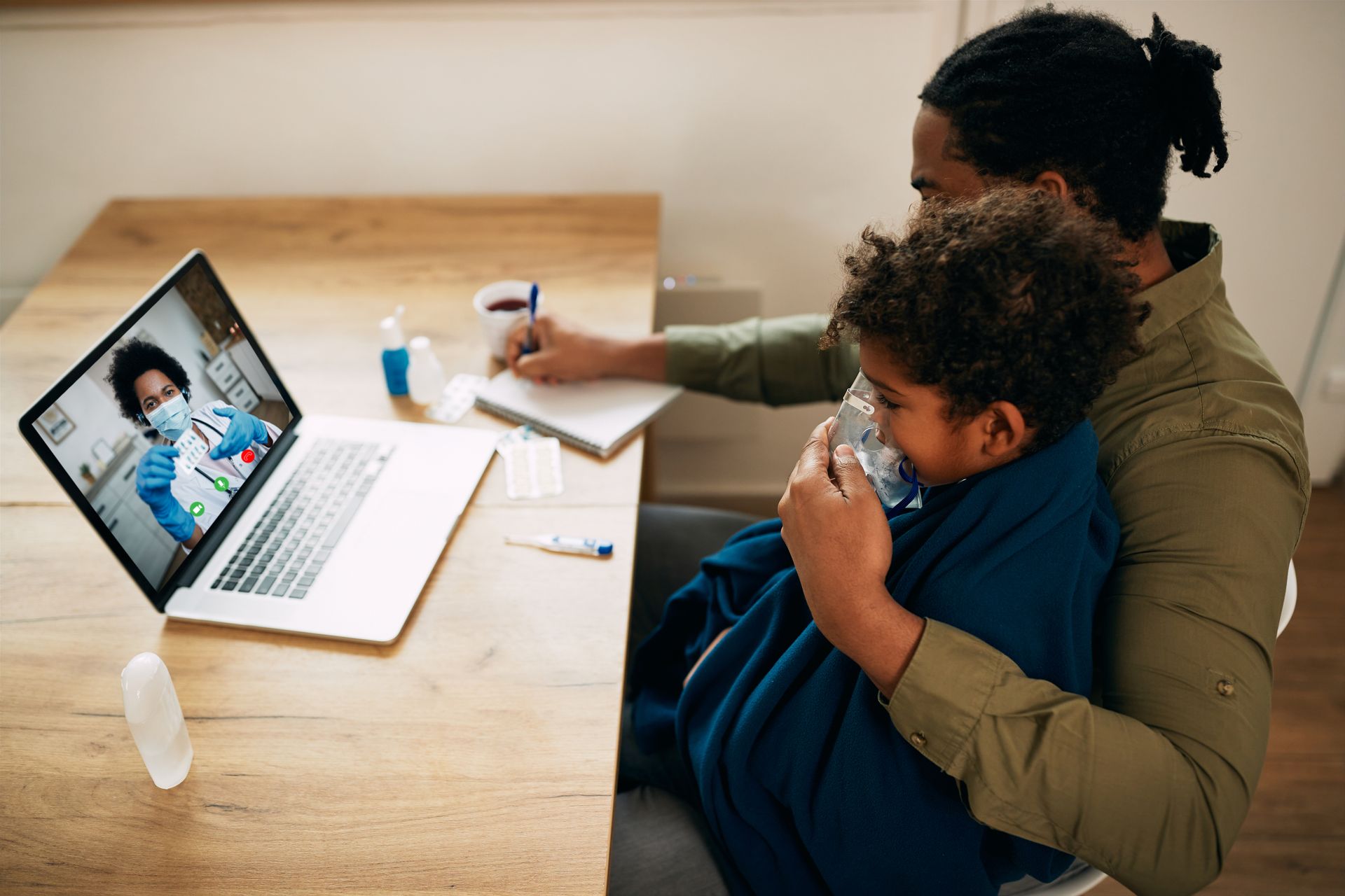 A father and a sick child consult a doctor from their home using telemedicine services.