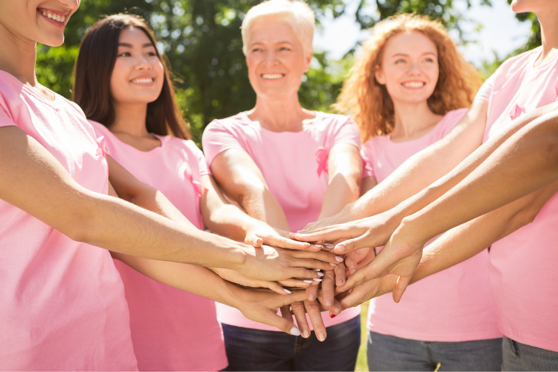 Women wearing pink and pink ribbons gather together to support Breast Cancer Awareness Month.