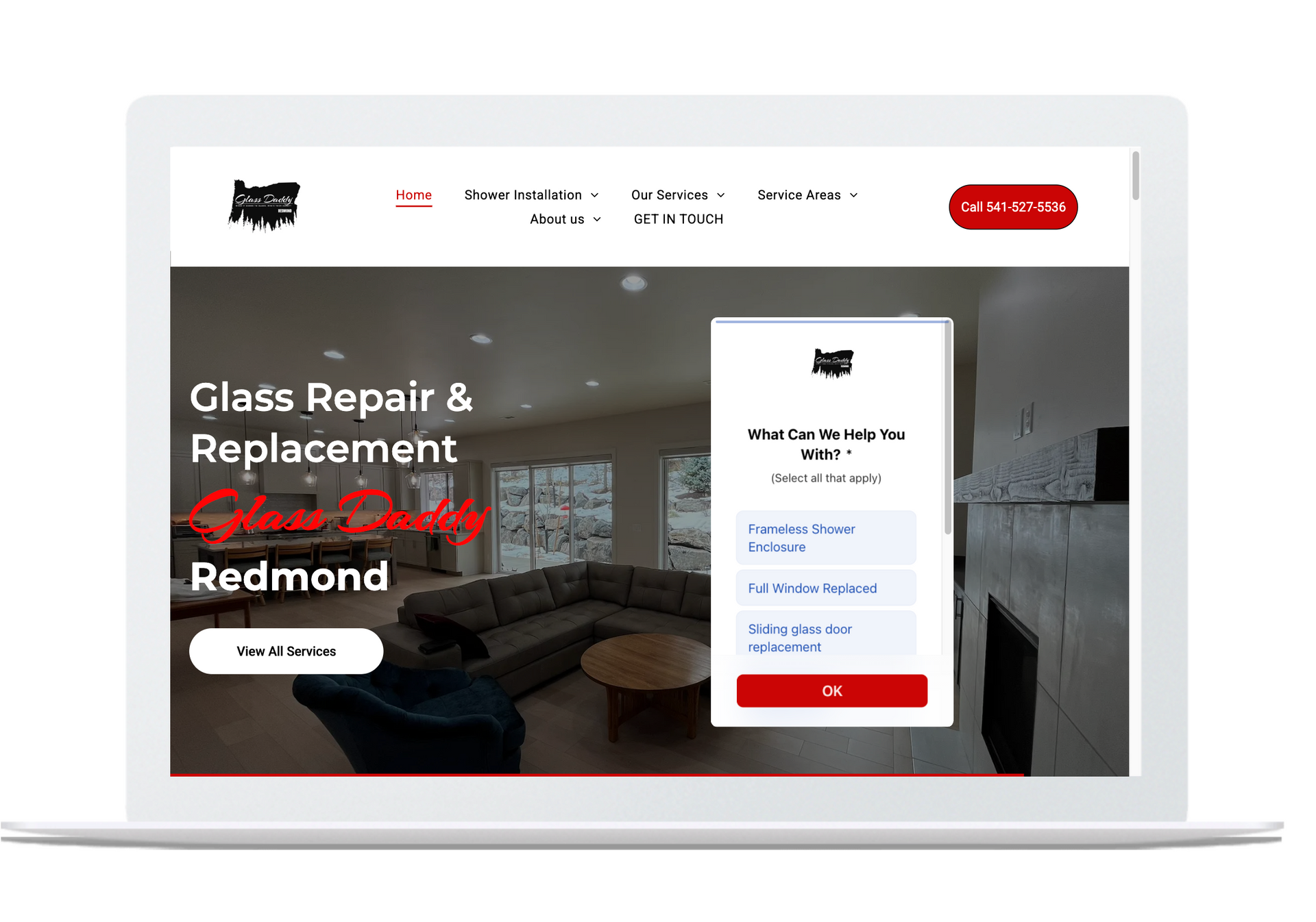 Laptop showing glass repair website with red accents and a repair quote form on the screen