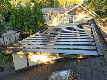 An aerial view of a roof of a house with a standing seam metal roof.